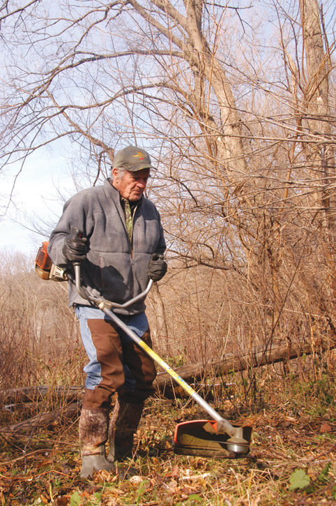 Trimming weeds to make deer trail